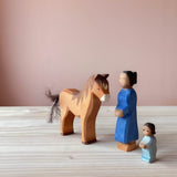 Ostheimer Tierfigur braunes Pferd aus Holz und dazu die Spielfiguren Frau und Wickelkind.