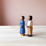 Die Ostheimer Spielfiguren Mutter und Vater stehen nebeneinander auf einer Holzplatte und schauen schräg nach vorne.