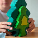 Das Steckspiel Tanne von Glückskäfer wird von einem Kind seitlich gehalten und die Teile werden leicht auseinander geschoben.