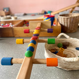 Pikler Spielraum von Kokomoo - offene Spielmaterialien auf Hengstenberg Speilgeräten aufgebaut, daneben ein großer runder Tablettkorb.