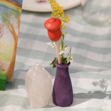 Die Holztulpe in der kleinen Holzvase vom Grapat "Your Day" Ergänzungsset zum Jahreskalender, gemeinsam mit frischen Blumen, daneben steht ein Bergkristall.