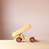 Der LKW Anhänger von Fagus aus Holz von der Seite, die Ladefläche ist hochgekippt.