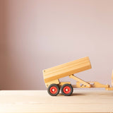 Der Fagus Anhänger für den Muldenkipper aus Holz, seitlich, angehängt an eine Zugmaschine, die Ladefläche flach, in der ersten Position, hochgekippt.