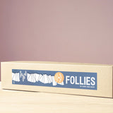 Die Kartonverpackung der keilförmigen Follies Holzbaustein, gut zu sehen, das Logo des Spiel-Gut Siegels.