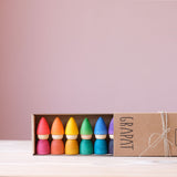 Die Grapat "Rainbow Tomtens", kleine Holzfiguren zum Spielen in Form von Zwergen in den sechs Regenbogenfarben in ihrer Verpackung.
