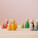 Grapat Nins Holzfiguren, ungefähr 6 Zentimeter groß und Grapat Baby Nins Spielfiguren stehen in Gruppen zusammen.