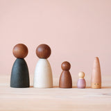 Fünf Holzfiguren zum Spielen von Grapat nebeneinander: ein Grapat "Sticks" ein "Nins", ein "Baby Nins" und zwei "Adult Nins" mit dunklem Holzkopf.