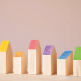 Die sechs verschieden großen Holzbausteine "Houses" von Grapat mit den bunten Dächern in Regenbogenfarben.