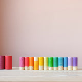 Alle zwölf großen Lola Spielfiguren von Grapat in einer Reihe farblich sortiert.