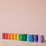 Coins von Grapat in Regenbogenfarben: die bunten 72 Holzplättchen sind nach Farben sortiert, je ein Stapel mit 6 Plättchen nebeneinander.