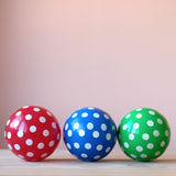 Die drei kleinen Spielbälle "Tupfenball", Durchmesser 13cm in rot, blau und grün, jeweils mit weißen Tupfen liegen nebeneinander.