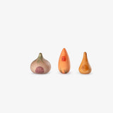 Drei Spielfiguren aus Holz von Grapat Lucky Lucky 4 in der Form von Zwiebeln, die auch ein bisschen wie kleine Häuser aussehen.