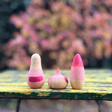 Holzfiguren "Familie Yay" von Grapat nebeneinander aufgestellt.