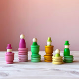 Grapat Holzfiguren-Set "Aquamarina Spring" alle 45 Teile teilweise zu verschiedenen Türmen gebaut: 3 Töpfchen, 6 Nins, 9 Holzplättchen und 9 Holzringe in den Farben rosa, grün und gelb.