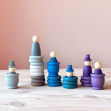Grapat Holzfiguren-Set "Aquamarina Winter", alle 45 Teile zu Türmchen gebaut: 6 Nins Holzfiguren mit oder ohne Hut, 3 Töpfchen, 9 Rings und 9 Coins in blau, lila und grau.