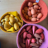 Drei runde Körbchen in gelb, orange und pink. In jedes Jutekörbchen sind kleine, farblich passende Mandalaholzsteine in unterschiedlichen Farben sortiert.