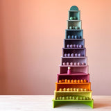 Mit den halbkreisförmigen Bauplatten von Grimms und den Bogen vom großen Grimms Regenbogen ist ein hoher Turm gebaut, in dem farblich passenden Filzkugeln in den einzelnen Stockwerken liegen.