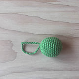 Ein grasgrüner Häkelball mit Schlaufe von Kokomoo.
