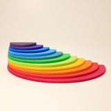 Grimms Regenbogen Bauplatten übereinander gestapelt zu einer Halbkreis-runden Pyramide, Richtung Rundung fotografiert.