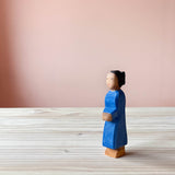 Ostheimer Holzfigur Mutter mit dunkler Hautfarbe und dunklem Haar, steht in blauem Kleid mit Blick seitlich nach vorne.