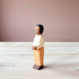 Die Ostheimer Spielfigur Vater aus Holz steht auf einer Holzplatte und schaut schräg nach vorne.