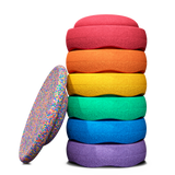 Ein gestapeltes Stapelstein® Bundle Classic in Regenbogenfarben, daran lehnt ein Confetti Board.