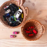 Der große runde Weidenkorb von Kokomoo gefüllt mit kleinen Spielzeugautos, daneben der kleine runde Weidenkorb mit nur roten Autos.