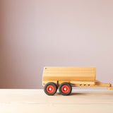 Der Fagus Anhänger für den Muldenkipper aus Holz, seitlich, angehängt an eine Zugmaschine.