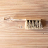 Ein kleiner Handbesen zum Kehren aus Holz mit Naturborsten.