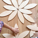 Die Blätter-förmigen Holzplatten "Petals Platforms" von Grapat zu Blüten am Boden aufgelegt.