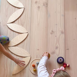 Ein Weg aus Blütenblätter Holzplatten von Grapat wird von zwei Kindern am Boden aufgebaut.