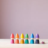 Die Grapat "Rainbow Tomtens", kleine Holzfiguren zum Spielen in Form von Zwergen in den sechs Regenbogenfarben nebeneinander aufgestellt.