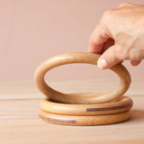 Drei Stück Grapat "Big Hoops" große Holzringe aufeinander gelegt, der obere wird gerade hoch gehalten.