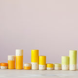 Die gelben, orangen und hellgrünen Lolas von Grapat in drei verschiedenen Größen farblich sortiert in einer Reihe.