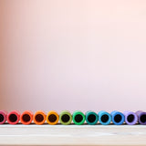 Die bunten Becher aus Holz vom Grapat Spielmaterial Lola aufgereiht, farblich sortiert.