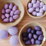 Die drei verschiedenen Lila-Töne der Grapat Mandala Eggs in drei Jutekörbchen farblich sortiert, daneben drei flieder farbene Kokomoo Häkelbälle.