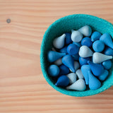 Ein blaues Jutekörbchen gefüllt mit den blauen Grapat Mandala Legematerial namens Regentropfen.