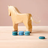 Eine Holzpferd Spielfigur, davor sieben Mandala Steine von Grapat "Little Coin" - also drei kleine Holzplättchen in verschiedenen Blautönen.