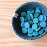 Grapat "Little Coins" - blaue Mandala Steine in Plättchenform für das freie Spiel in einem blauen Jutekorb.