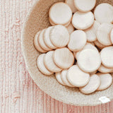 Grapat "Coins" Holzplättchen für das freie Spiel ab 12 Monaten liegen in einem Jutekörbchen.