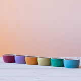 Die 6 Grapat "Bowls" Holzschalen in Erdfarben in einer Reihe aufgestellt.