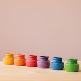 Die sechs Grapat "6 Bowls" Schälchen in den Farben des Regenbogens nebeneinander aufgestellt, in jedem steht ein farblich passendes Holztöpfchen.
