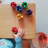 Fertig, alle kleinen Holzeicheln in Regenbogenfarben vom Sortierspiel Grapat "Acorns & Bowls" sind farblich passend in die Holzschälchen sortiert.