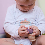 Ein Baby versucht einen Grapat Nin Holzfreund in einen Holzbecher Grapat Mates zu stecken und ist sehr konzentriert  bei der Sache.