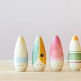 Vier Spielfiguren aus Holz von Grapat für das freie Spiel nebeneinander aufgestellt.